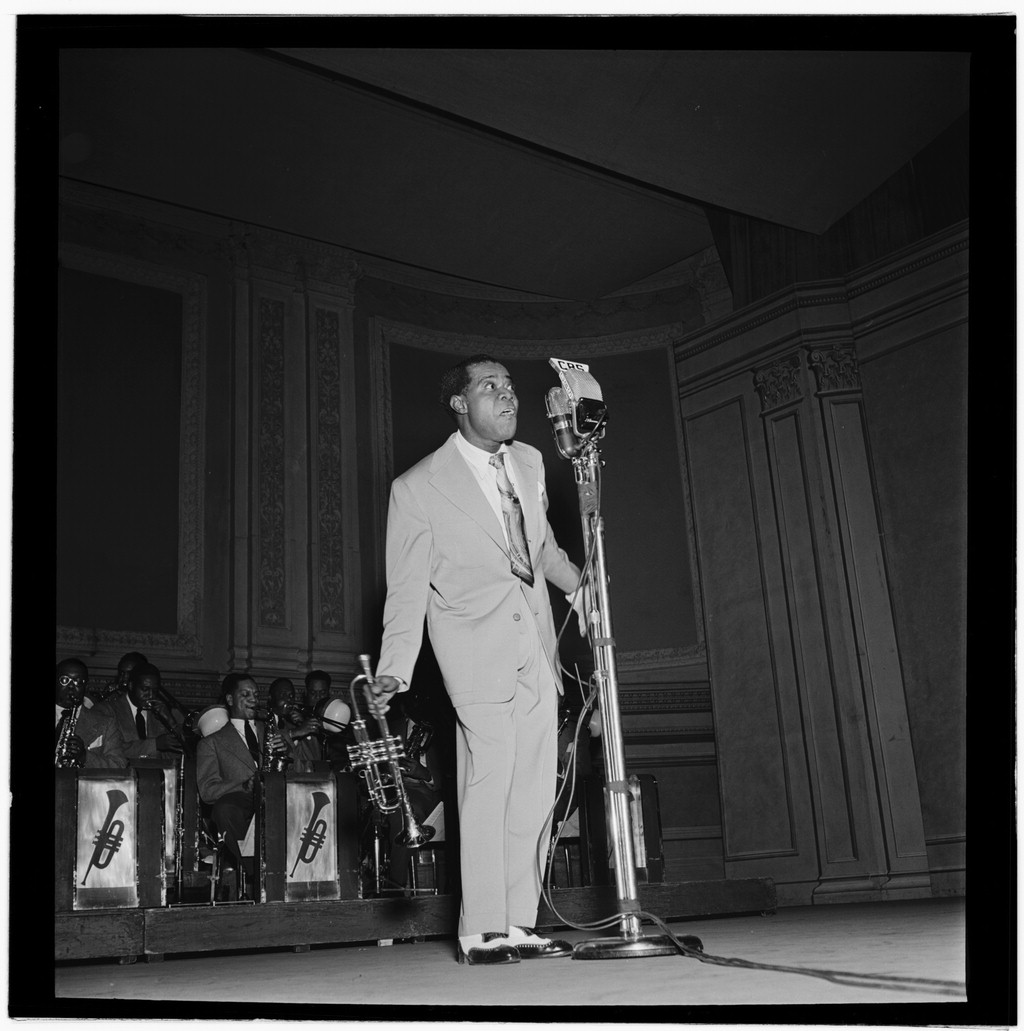 1947年2月、ニューヨークのカーネギーホールでマイクに口をつけるLouis Armstrong