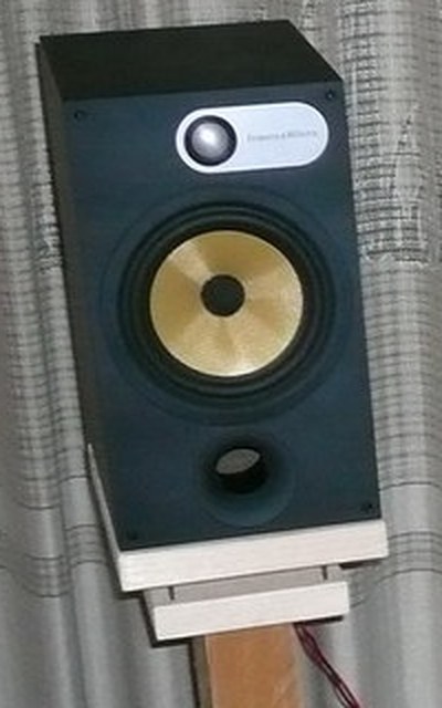 スタンドに載せたBowers & Wilkins 685（ブラックアッシュ）。上部にシルバーのツイーター、中央に黄色いケブラーコーン、下部にFlowport