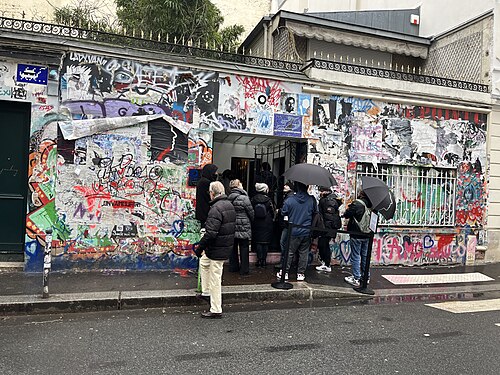 落書きで覆われたパリ7区ヴェルヌイユ通りのゲンスブール邸の外壁と訪れる人々