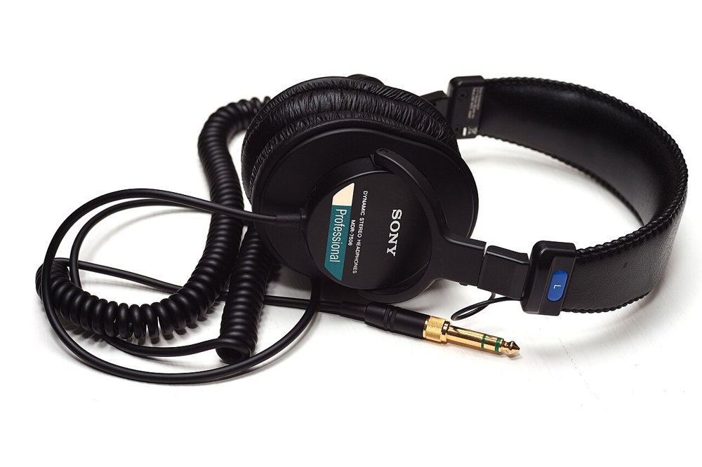黒いSony MDR-7506密閉型ヘッドホンと、カールコード、金メッキの標準プラグ