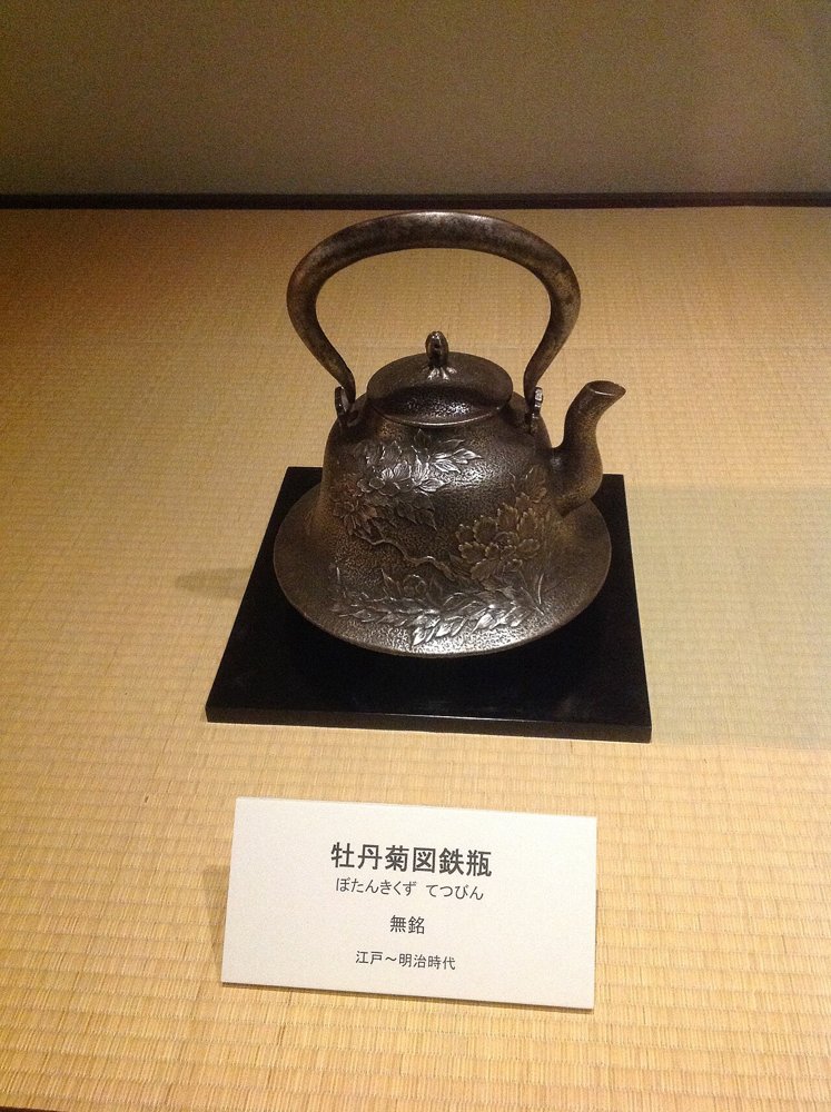 畳の上に展示された牡丹菊図鉄瓶