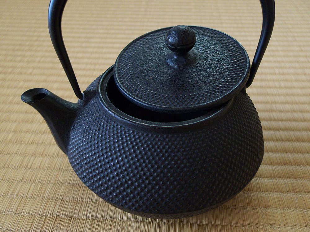 畳の上に置かれた霰文様の小ぶりな南部鉄器
