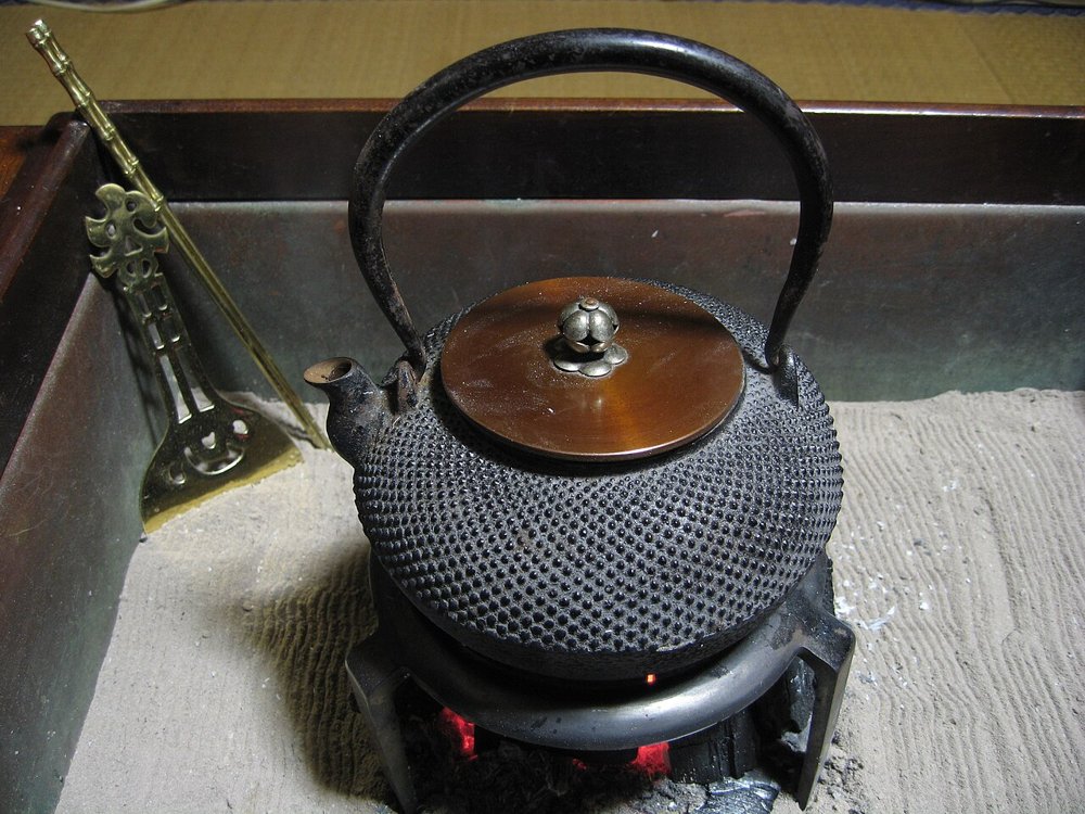 火鉢の炭火にかけられた霰文様の鉄瓶