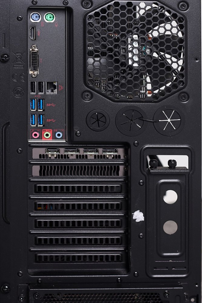 PCケースの背面。マザーボードのUSBや音声端子、グラフィックボードの映像出力、排気ファンの網目が見える