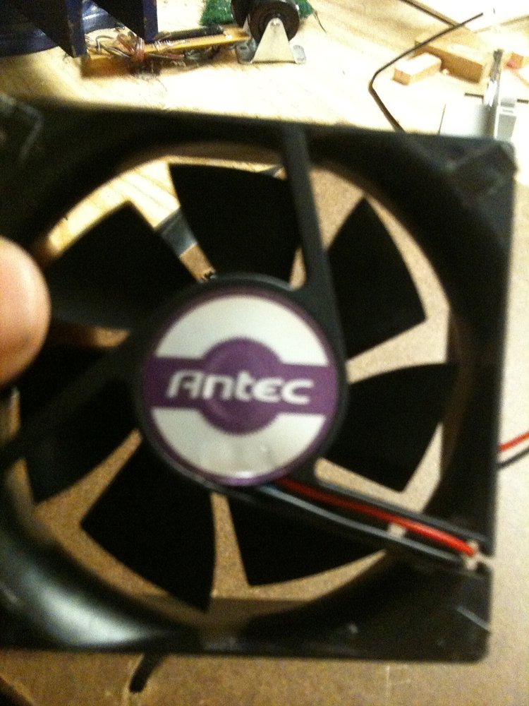 指でつまんで持った、Antecのロゴが入った80mmの小型ケースファン
